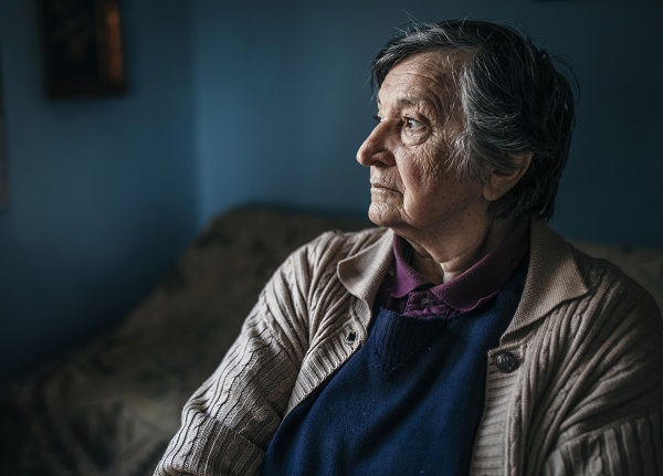 Photo of lonely senior woman sitting at a table and thinking.