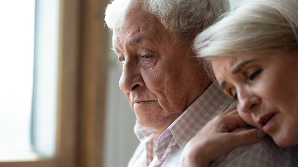 Worried middle aged woman comforting depressed elder husband, experiencing grief.